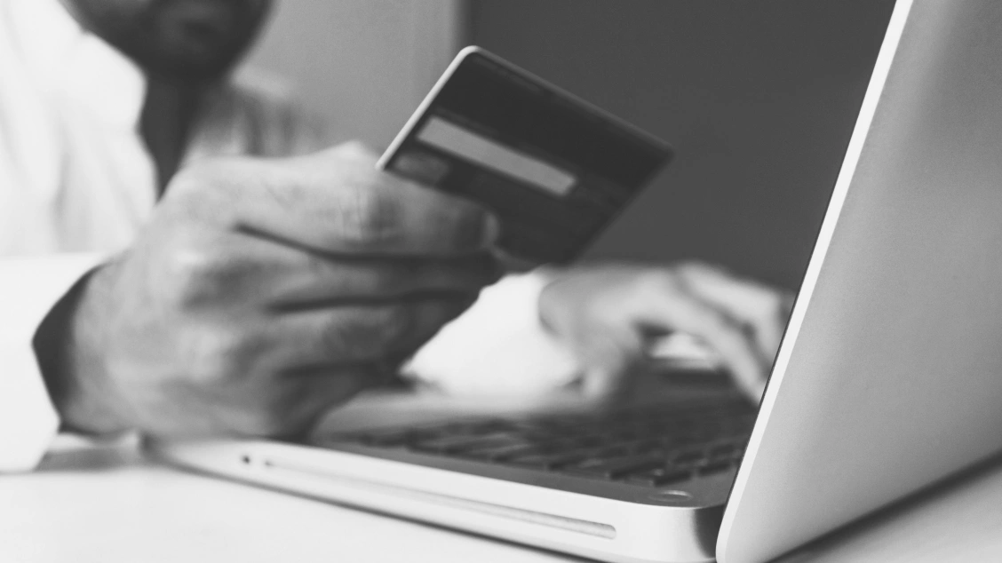 Person using laptop computer with credit card